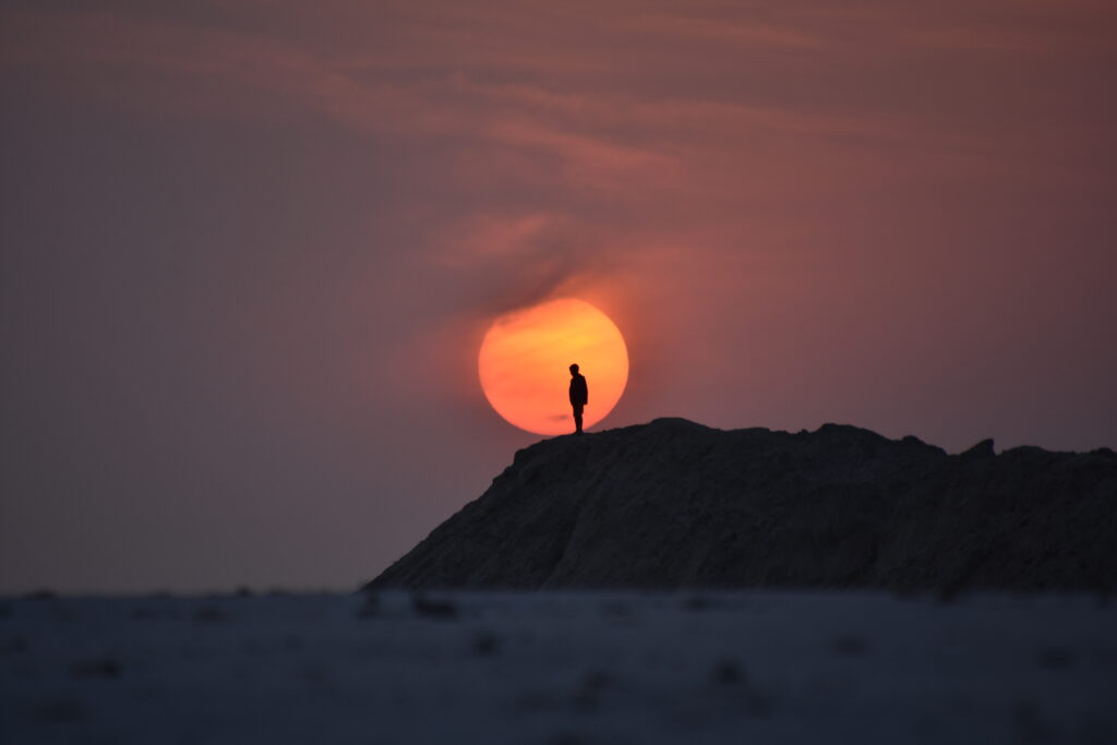 silhouette-person-rock-against-sky-sunset - Bidaya Global